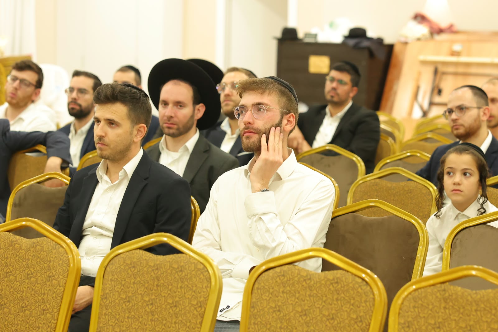 משתתפים יושבים ומאזינים לדברי החיזוק